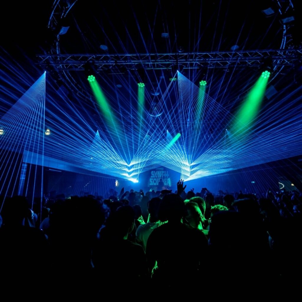 Foule dans un club avec lasers bleus et verts lors de la soirée PLAY HARD au D! Club Lausanne.