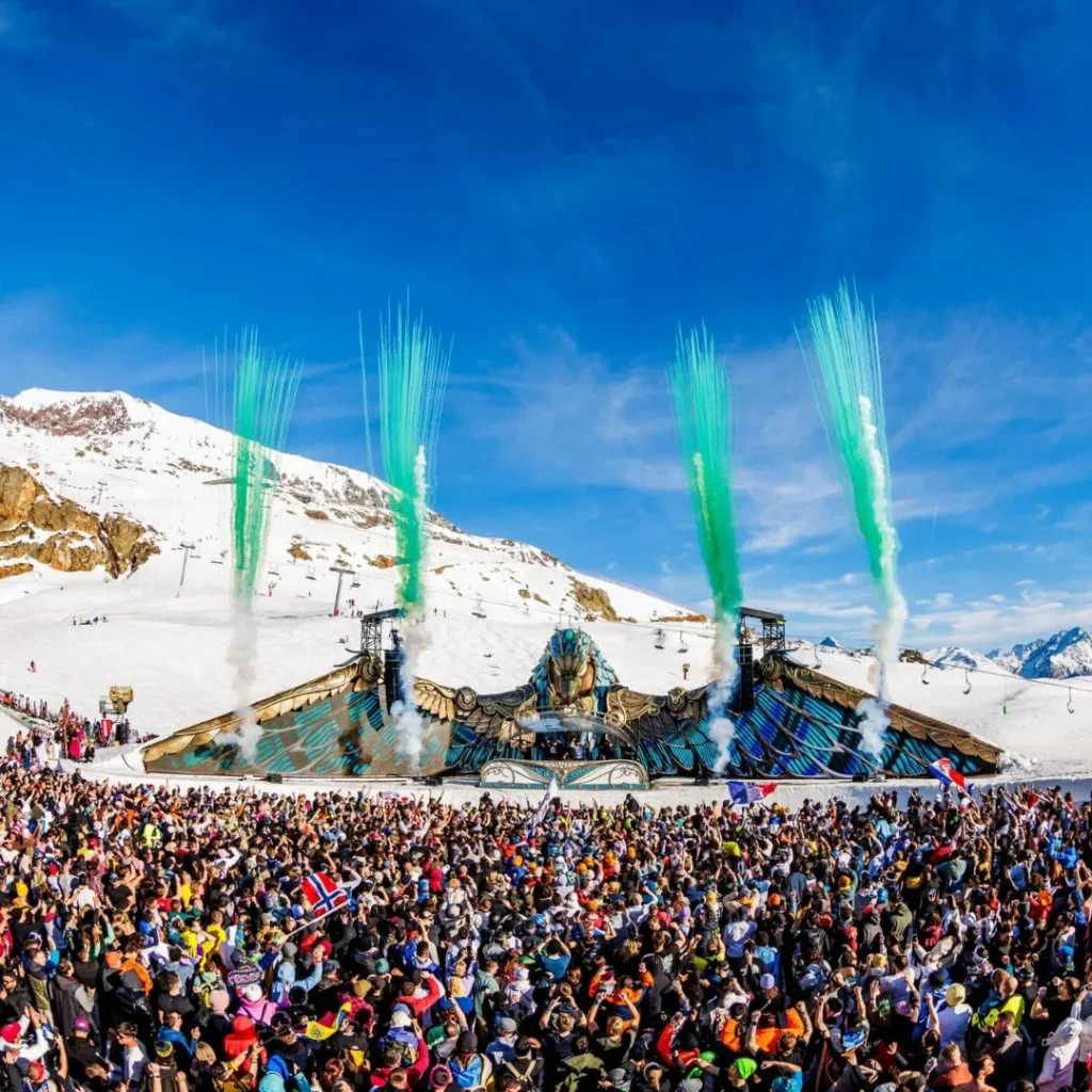 Scène principale du festival Tomorrowland Winter 2026 sous la neige à l'Alpe d'Huez avec une structure en forme d'aigle.