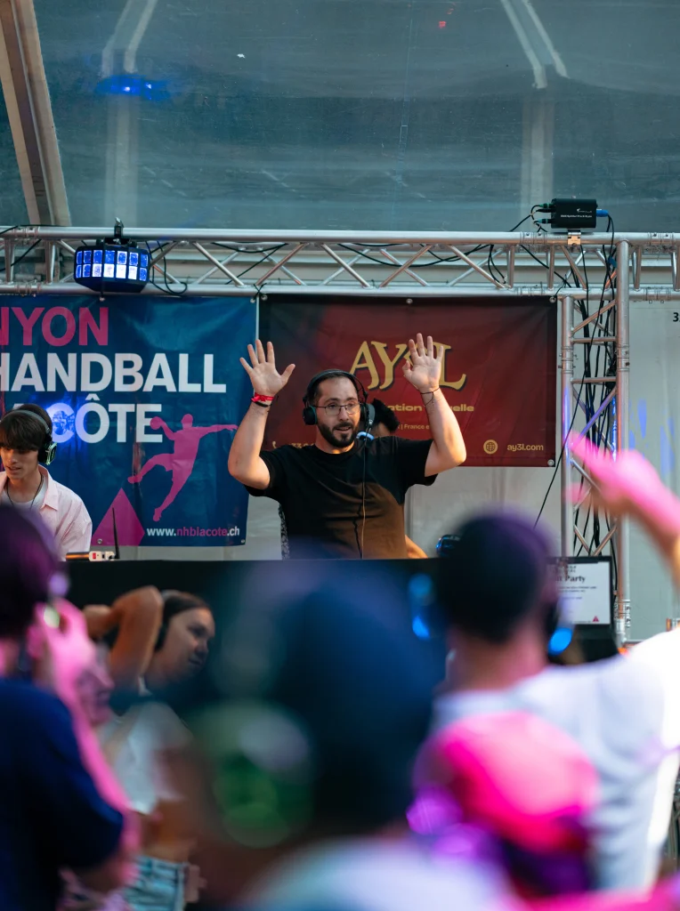 Le DJ Open Format AY3L lève les mains pour animer le public lors de son set à la Silent Disco du festival près de Nyon.